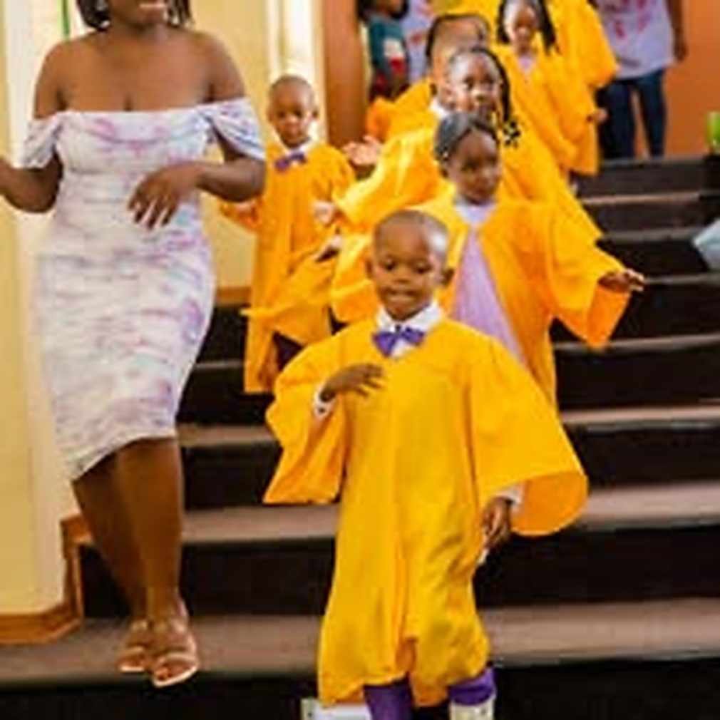 Children in graduation gowns walking down the steps at a Twinkle Toes graduation