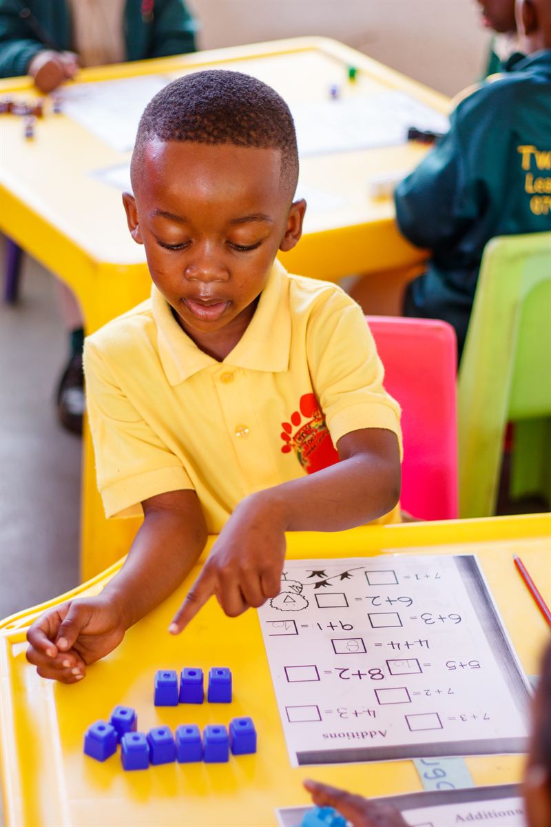 A Vantage Point learner using counting blocks to complete an addition worksheet