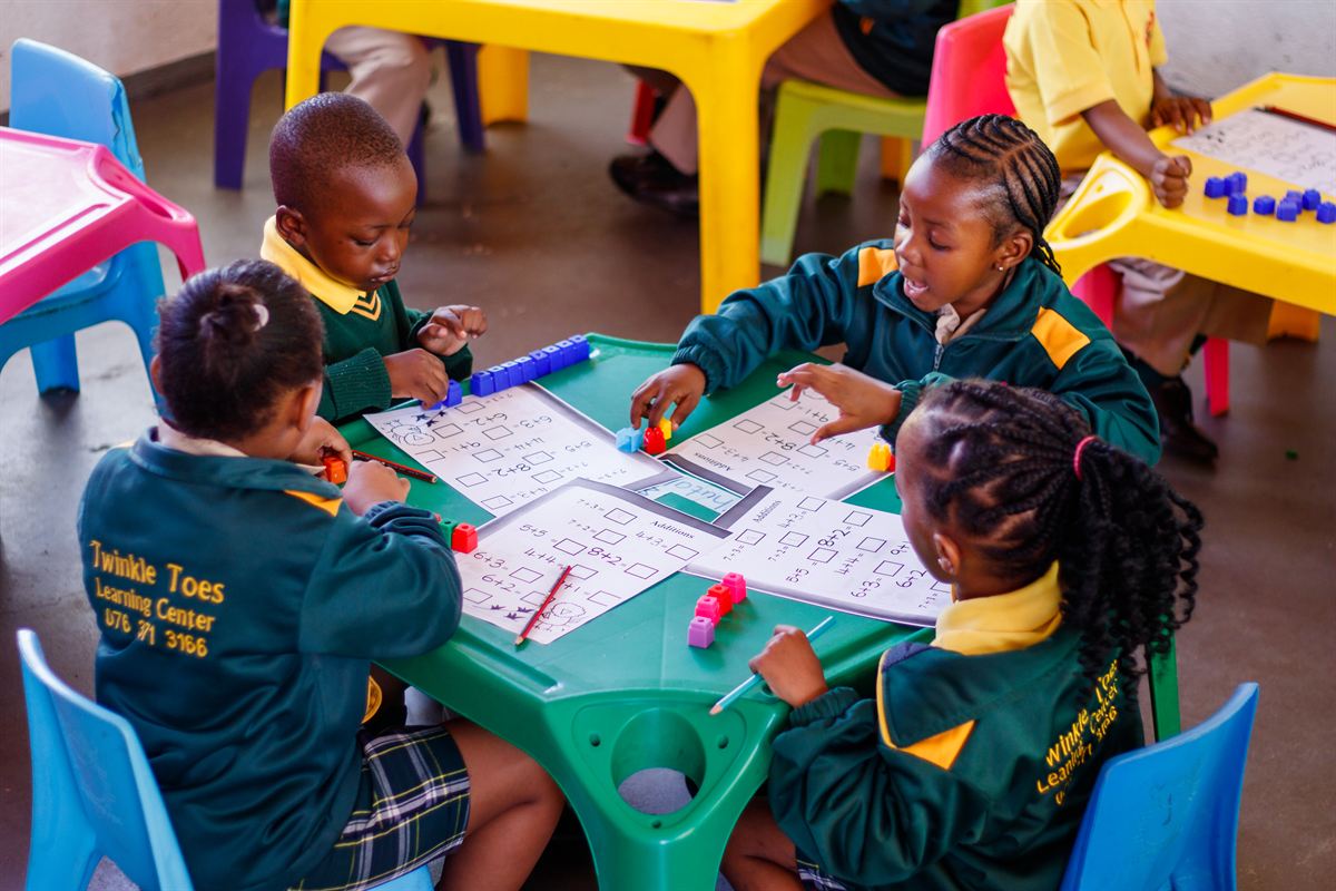 Vantage Point learners working together on addition worksheets with counting blocks